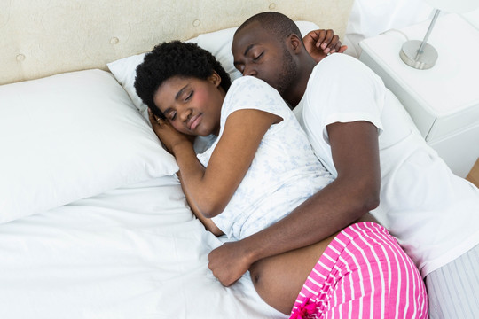 男人抱着怀孕的妻子睡觉