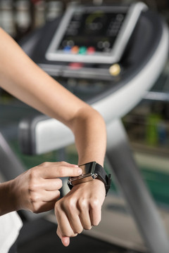 在健身房里使用智能手表的女人