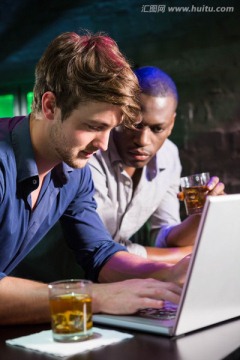 在酒吧使用笔记本电脑的商务男人