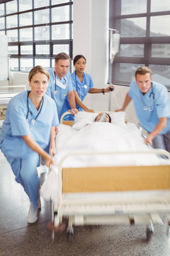 一群医生推着患者躺着的床