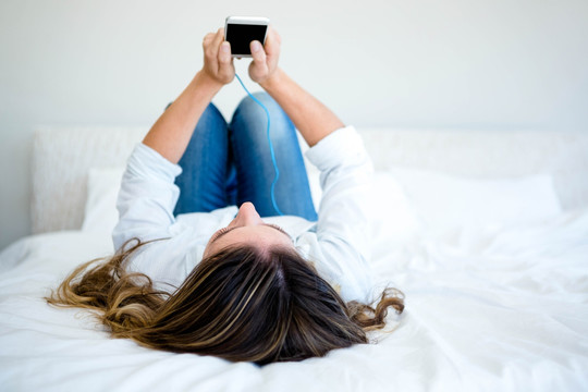 躺在床上使用手机的女人