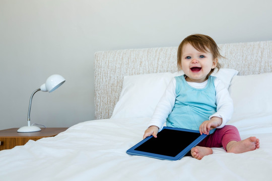 微笑的婴儿玩平板电脑