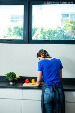 微笑的女人在厨房里切蔬菜