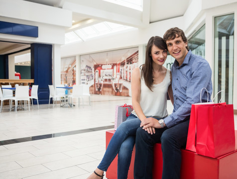幸福的一对夫妇坐在购物中心