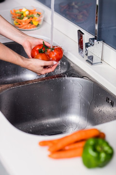女人在厨房洗脸盆洗西红柿