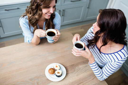 女人和朋友坐在厨房里喝咖啡聊天