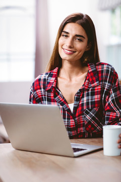 微笑的年轻女人在使用笔记本电脑