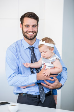 微笑的男商人抱着婴儿