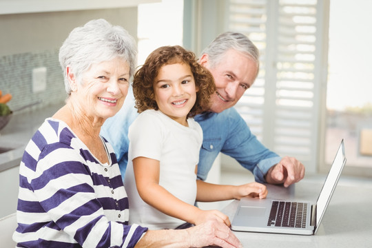 使用笔记本电脑的祖父母和孙女