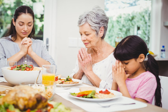 同奶奶在用餐前祈祷的母女