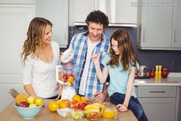 在厨房里榨果汁的父母和孩子们