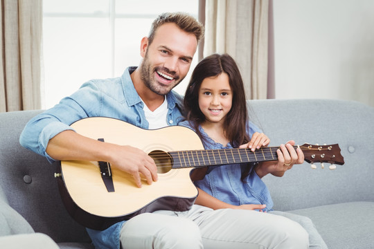 在弹吉他给女儿听的父亲