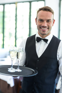 微笑的男服务员拿着香槟酒
