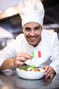 在菜肴中插一支意大利国旗的厨师