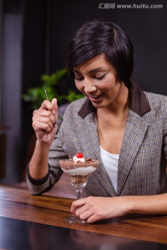 微笑的女人在咖啡馆里吃甜点