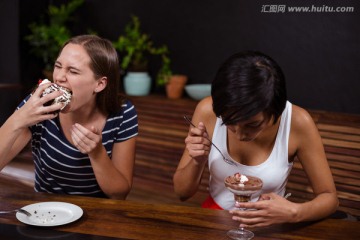 在在咖啡馆里大口吃蛋糕的女人