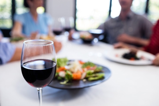 餐厅桌上的一盘沙拉和一杯红酒