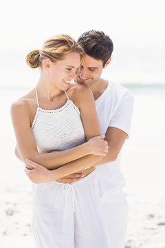 年轻夫妇拥抱在海滩上
