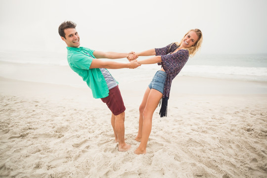 手拉手站在沙滩上的情侣