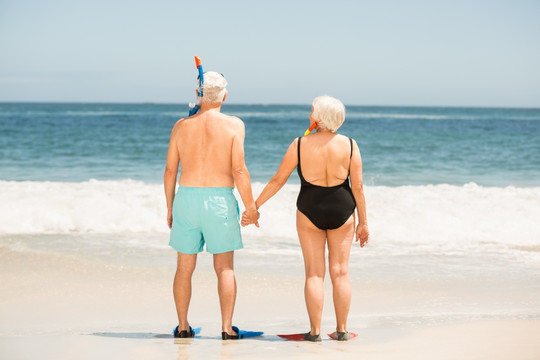 在海边穿着脚蹼的老年夫妇