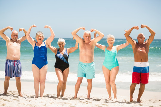 站在沙滩上展示肌肉的老人们