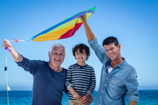 在海边玩风筝的父子和爷爷