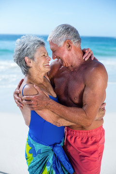 微笑的老夫妇在海边拥抱