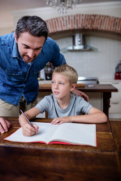 父亲在厨房里教儿子做家庭作业