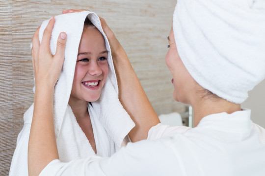 在用毛巾帮女儿擦干头发的母亲