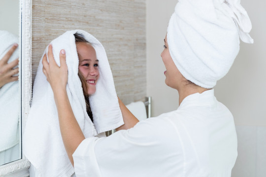 在用毛巾帮女儿擦干头发的母亲