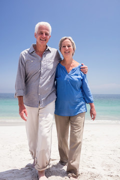 幸福的老年夫妇在海滩上散步