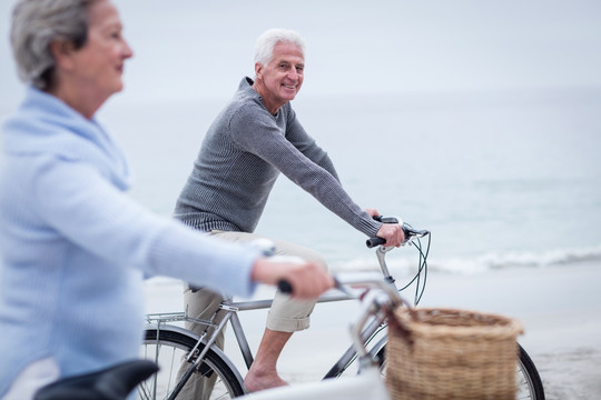 在海边骑自行车的老夫妇