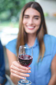 微笑的女人拿着一杯红葡萄酒