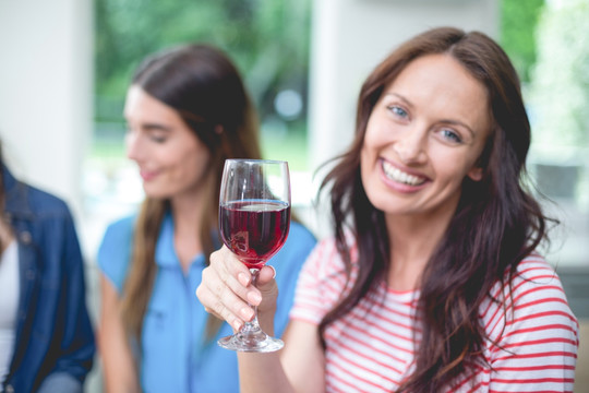 微笑的女人拿着一杯葡萄酒