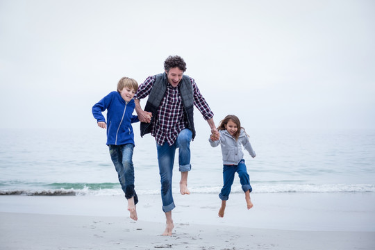 在海滩上奔跑的父亲和孩子