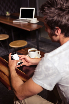 在咖啡馆里喝咖啡用手机的男人