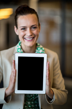 微笑着拿着平板电脑的商务女人