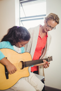 女老师在教学生弹吉他