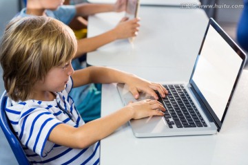 在教室里使用笔记本电脑的小学生