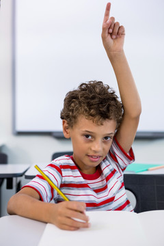 小学男孩举手在课堂上