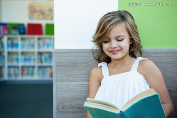 微笑的女孩在图书馆里看书
