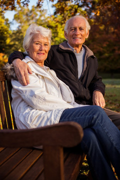 坐在长凳上微笑着的夫妇
