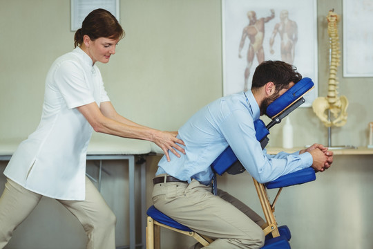 物理治疗师对患者给予背部按摩