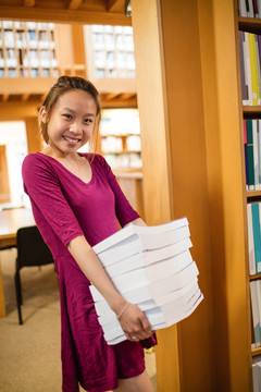 抱着一堆书的女大学生