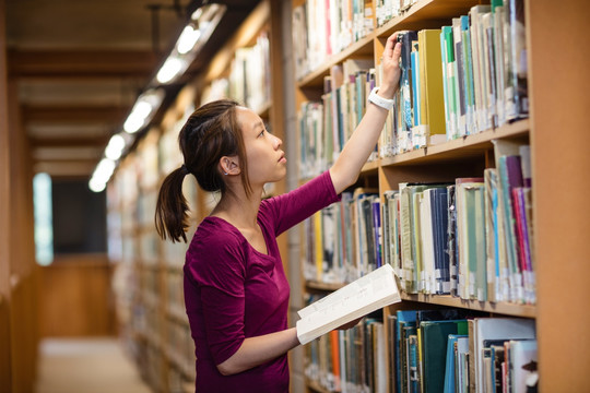 在图书馆里选书的女大学生