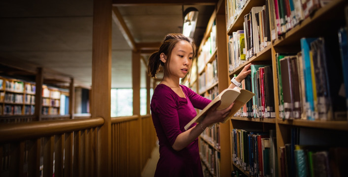 在图书馆里选书的女大学生