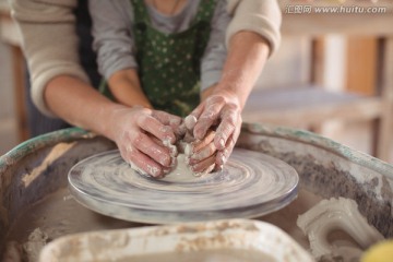 在协助女儿做陶器的母亲
