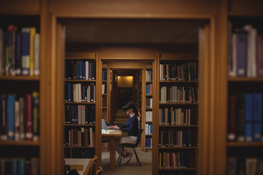 在图书馆使用笔记本电脑的女人
