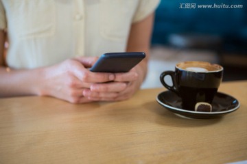 在咖啡馆里使用手机的女人