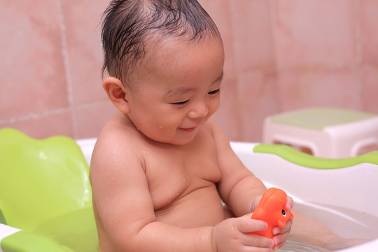 婴儿澡盆里自己开心玩耍的男宝宝